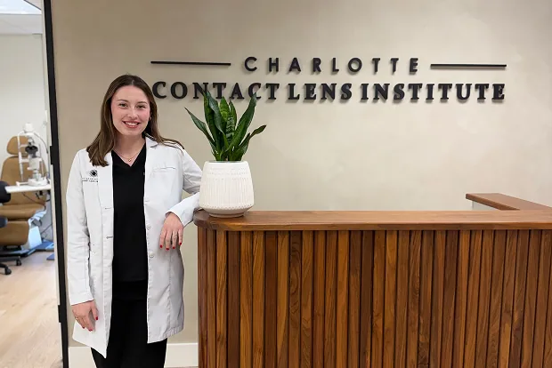 Dr. Sydney Walsh standing beside the Charlotte Contact Lens Institute reception desk