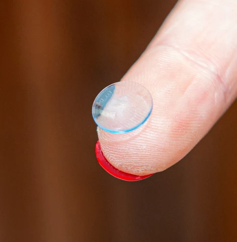 Corneal GP gas permeable contact lens on fingertip